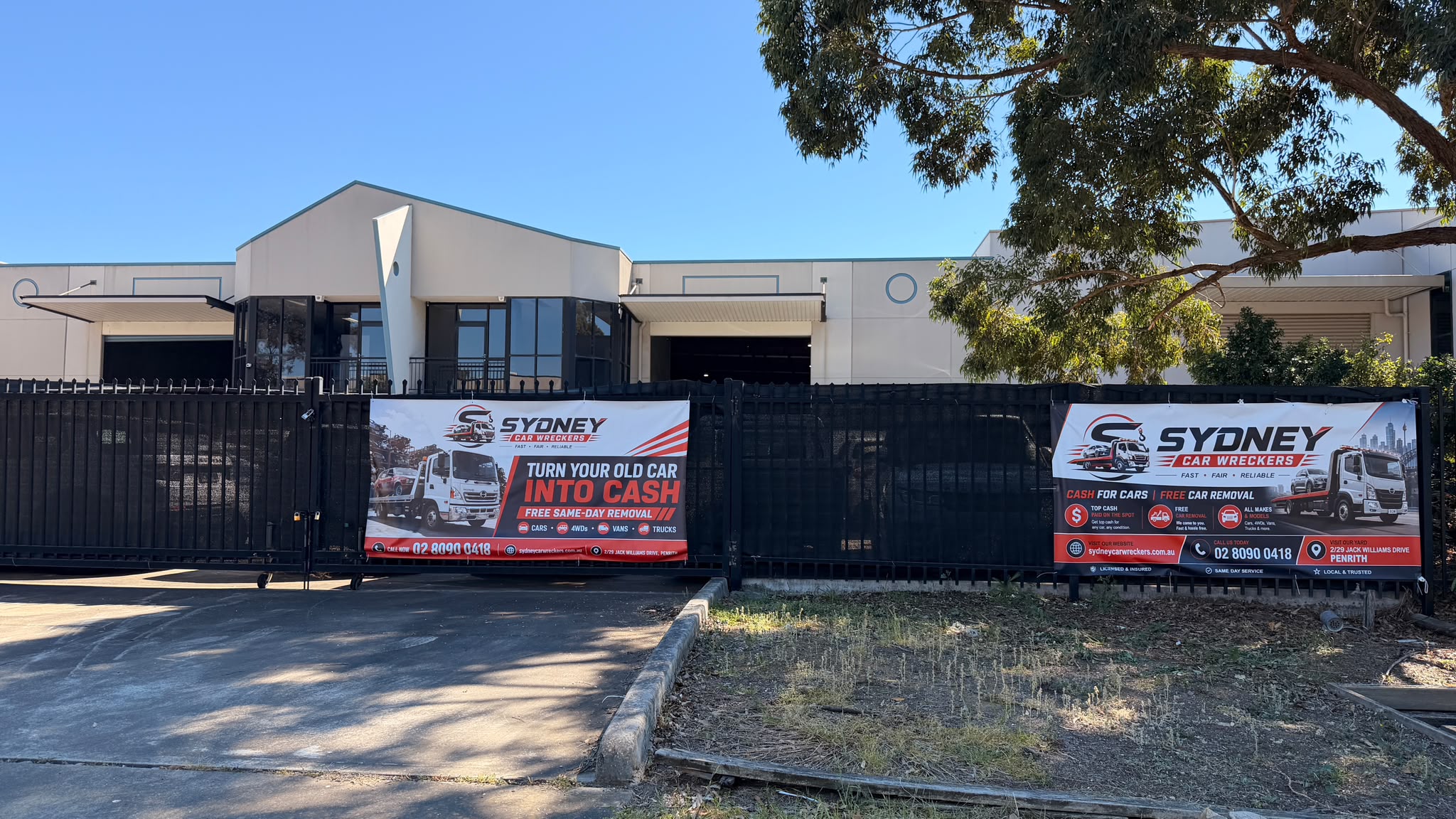 Sydney Car Wreckers yard entrance in Penrith with branded signs on the front fence.